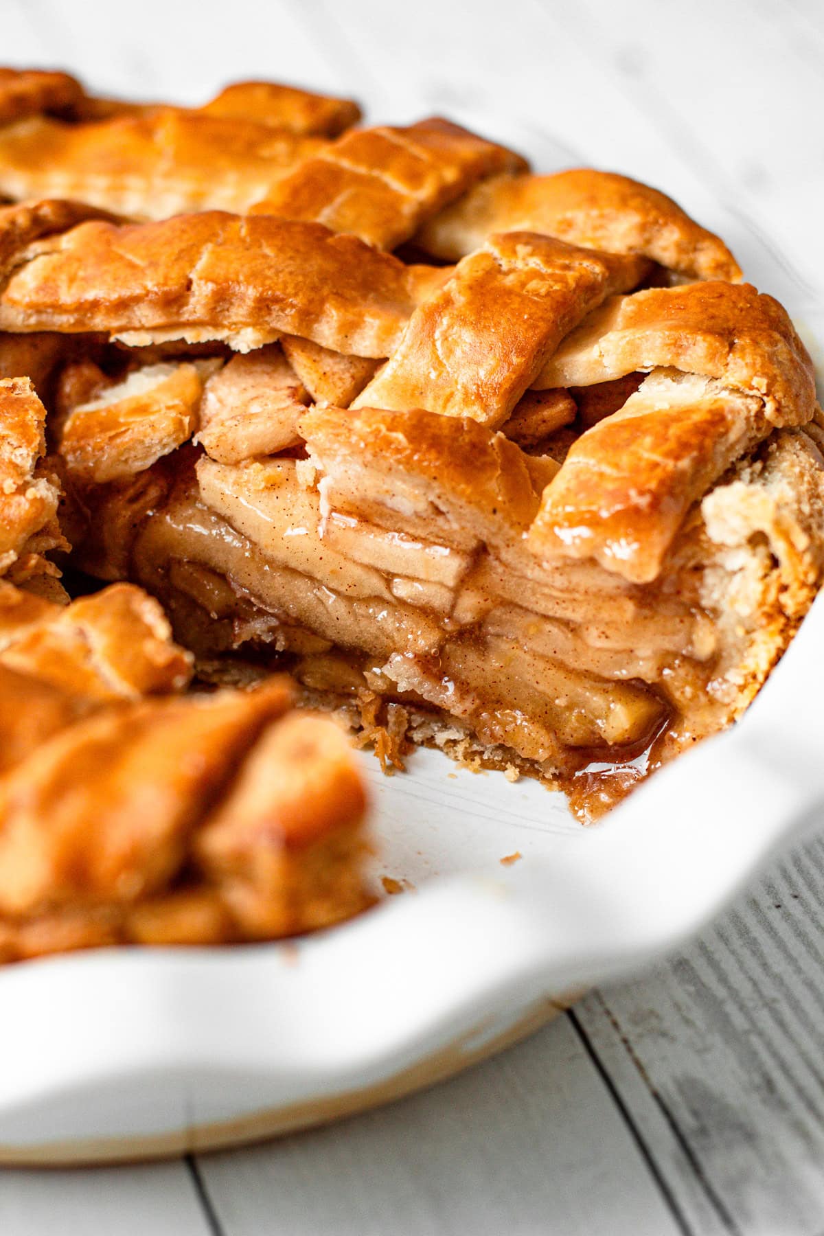 A gluten-free apple pie with a slice removed revealing the interior with juicy apples and perfect gluten free pie crust.