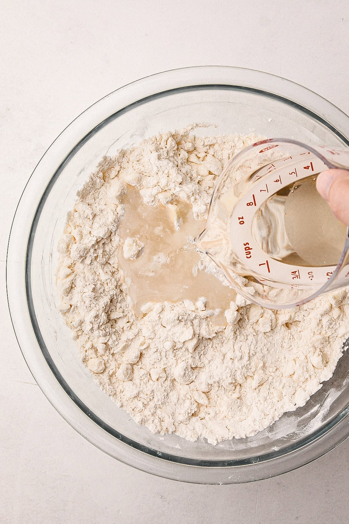 Pouring water into a pie crust mix.