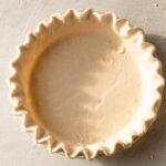 A shaped but unbaked gluten free pie crust.