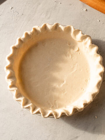 A shaped but unbaked gluten free pie crust.