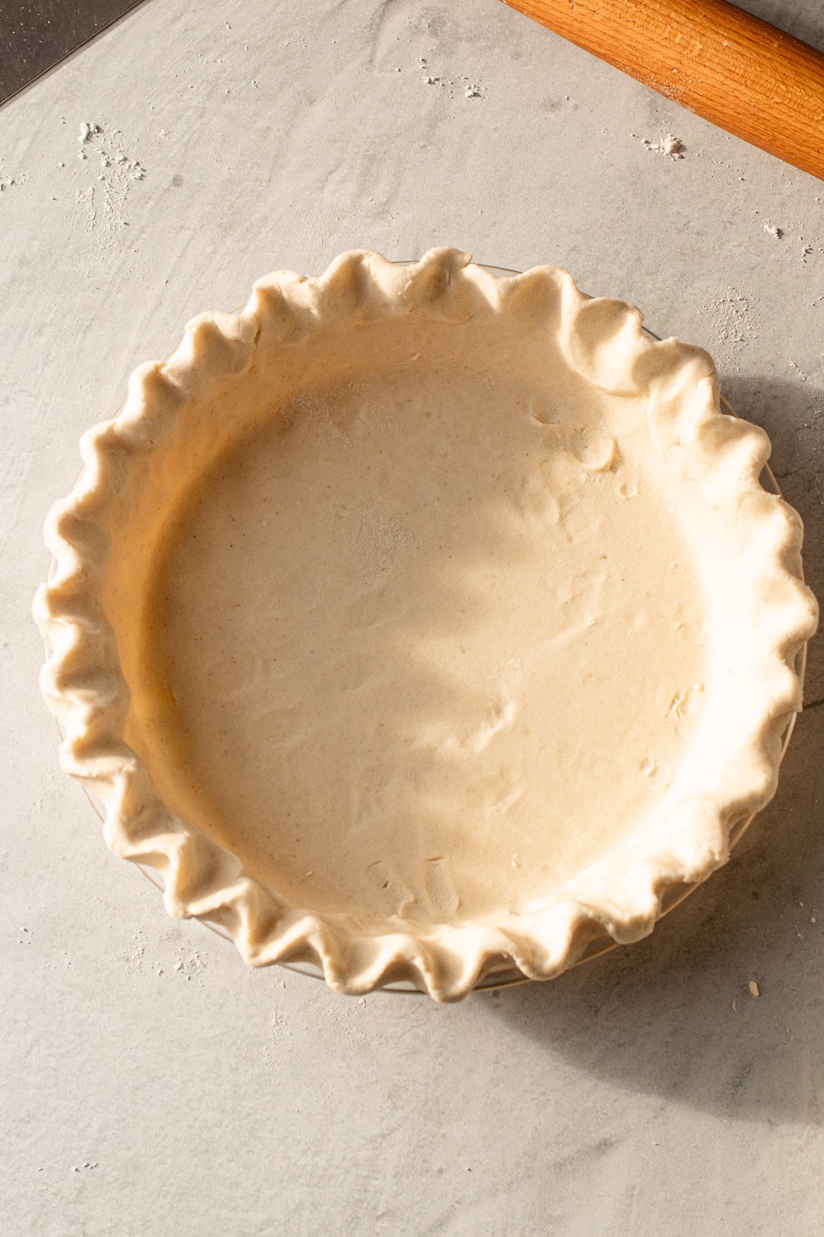 A shaped but unbaked gluten free pie crust.