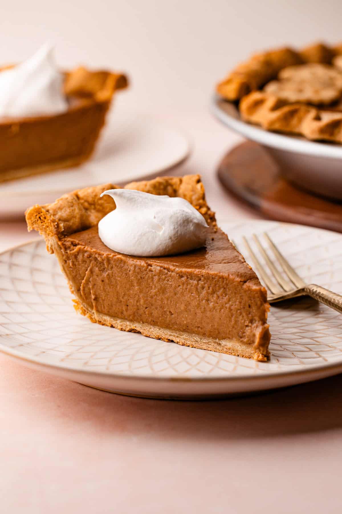 A slice of apple butter pie served on a plate with a dollop of whipped cream.