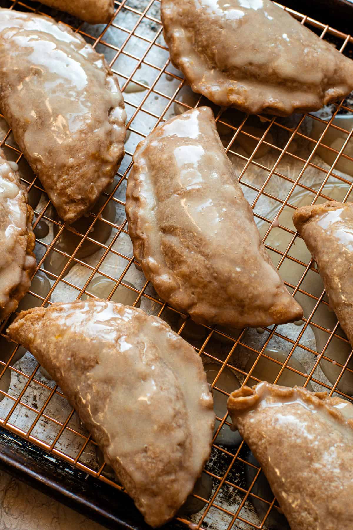 Baked and glazed pumpkin pasties on a cooling rack.