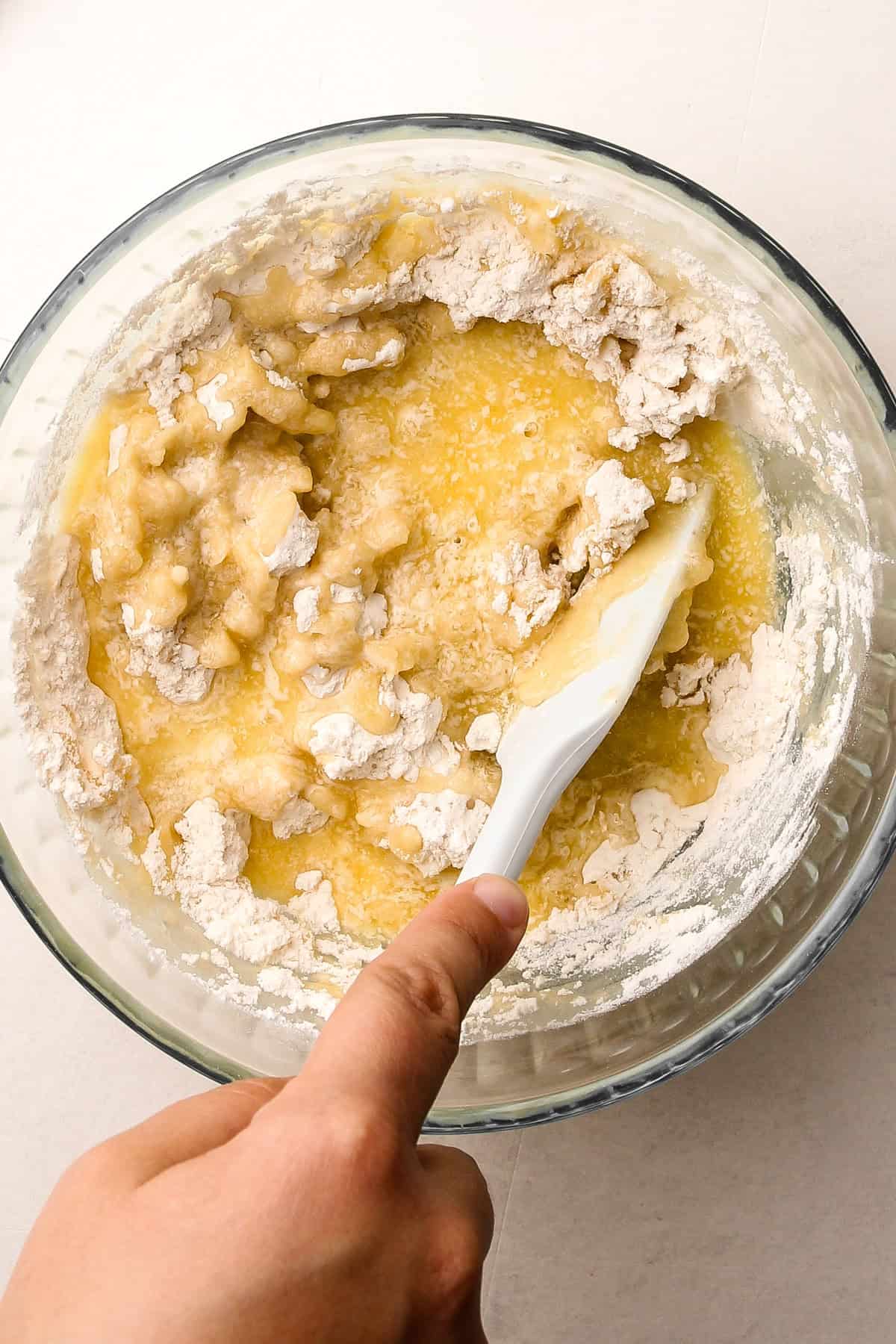 Mixing melted butter into flour for an easy press-in butter pie crust.