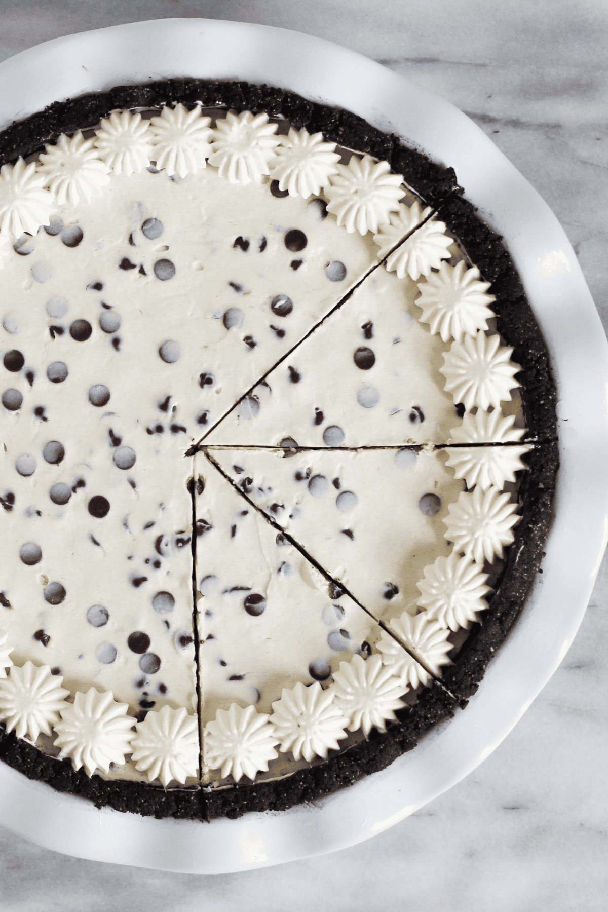 A prepared mint chocolate chip pie with a few sliced cut out.