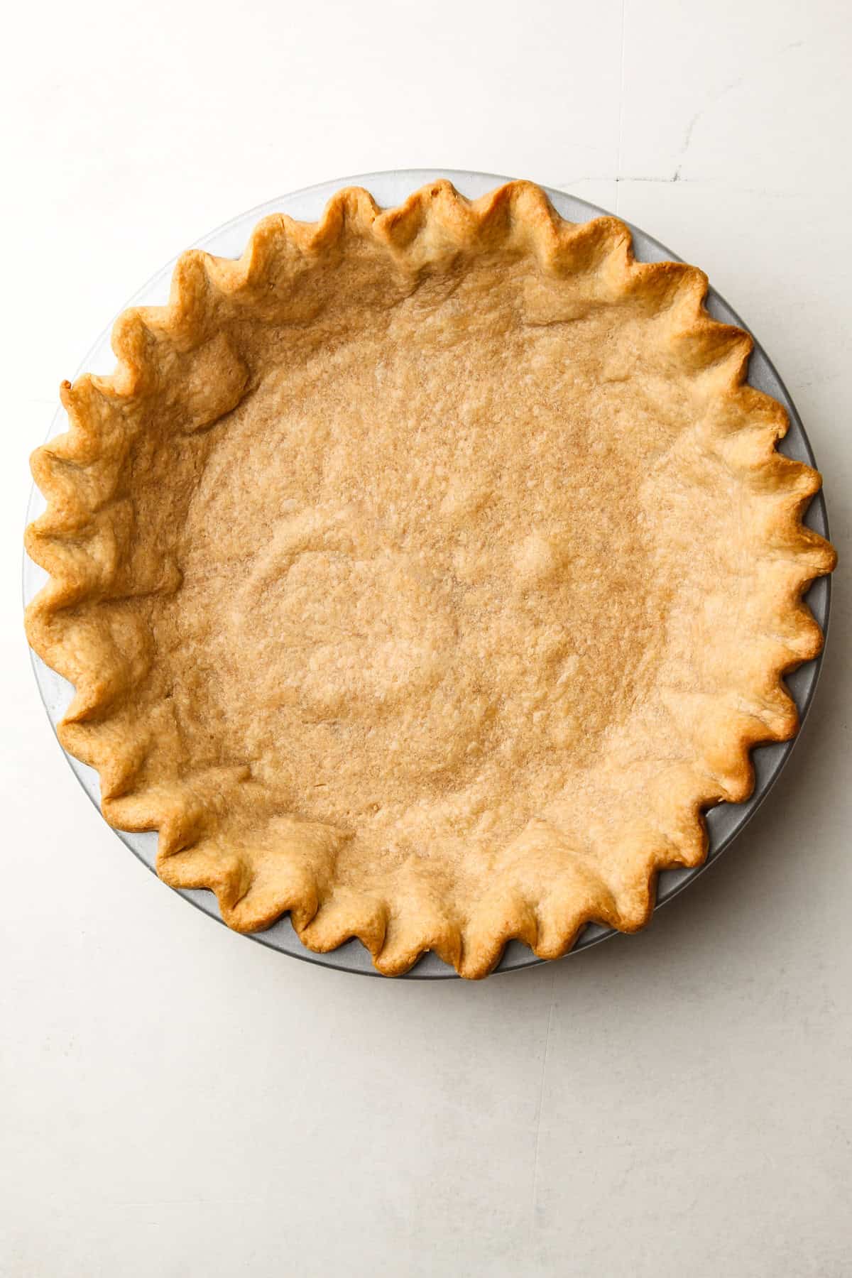 A whole wheat pie crust baked in a tin.