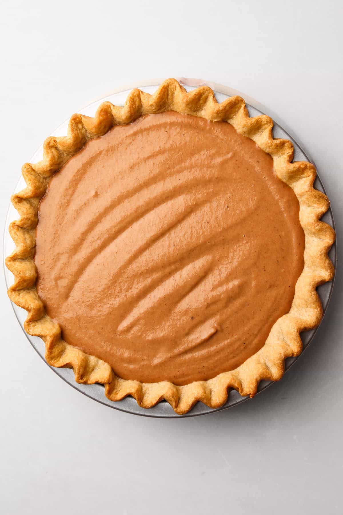 A whole wheat pie crust baked in a tin filled with a custard pie filling.