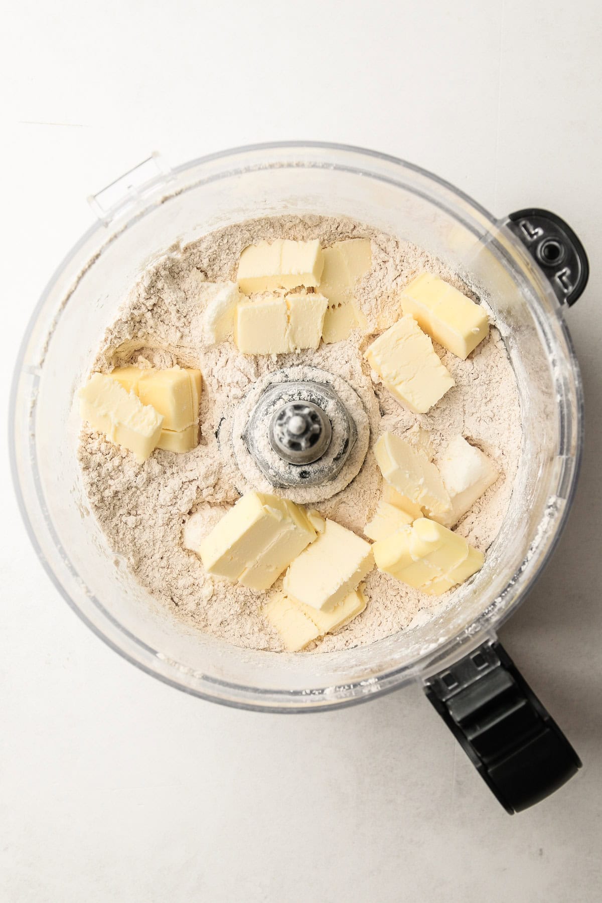 Whole wheat flour and chunks of butter in a food processor for pie crust made out of whole wheat.