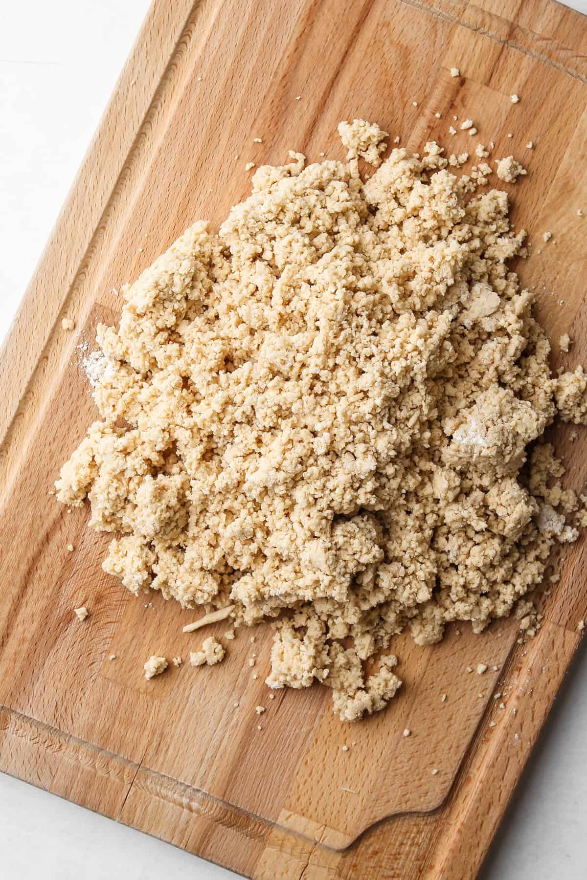 Whole wheat flour pie dough on a wooden board.