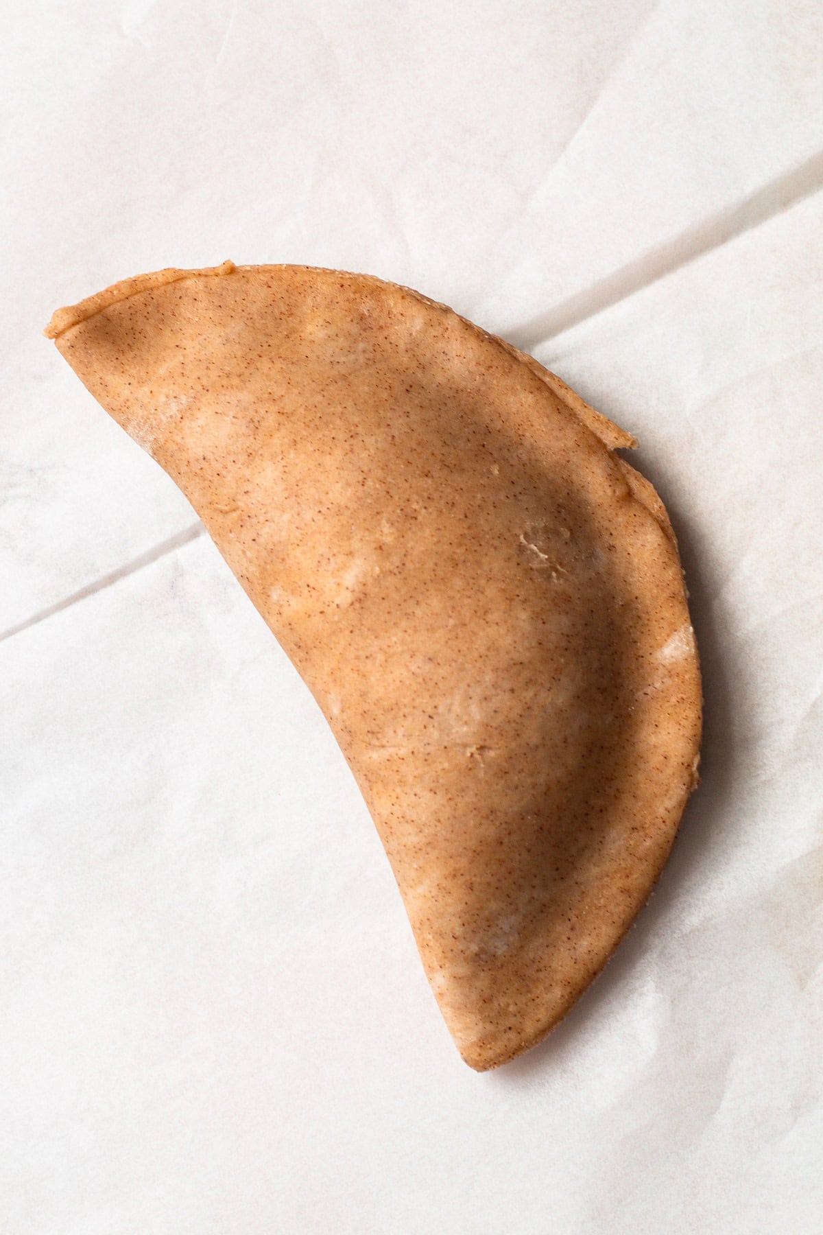 Folded pumpkin pasty dough, ready to crimp.