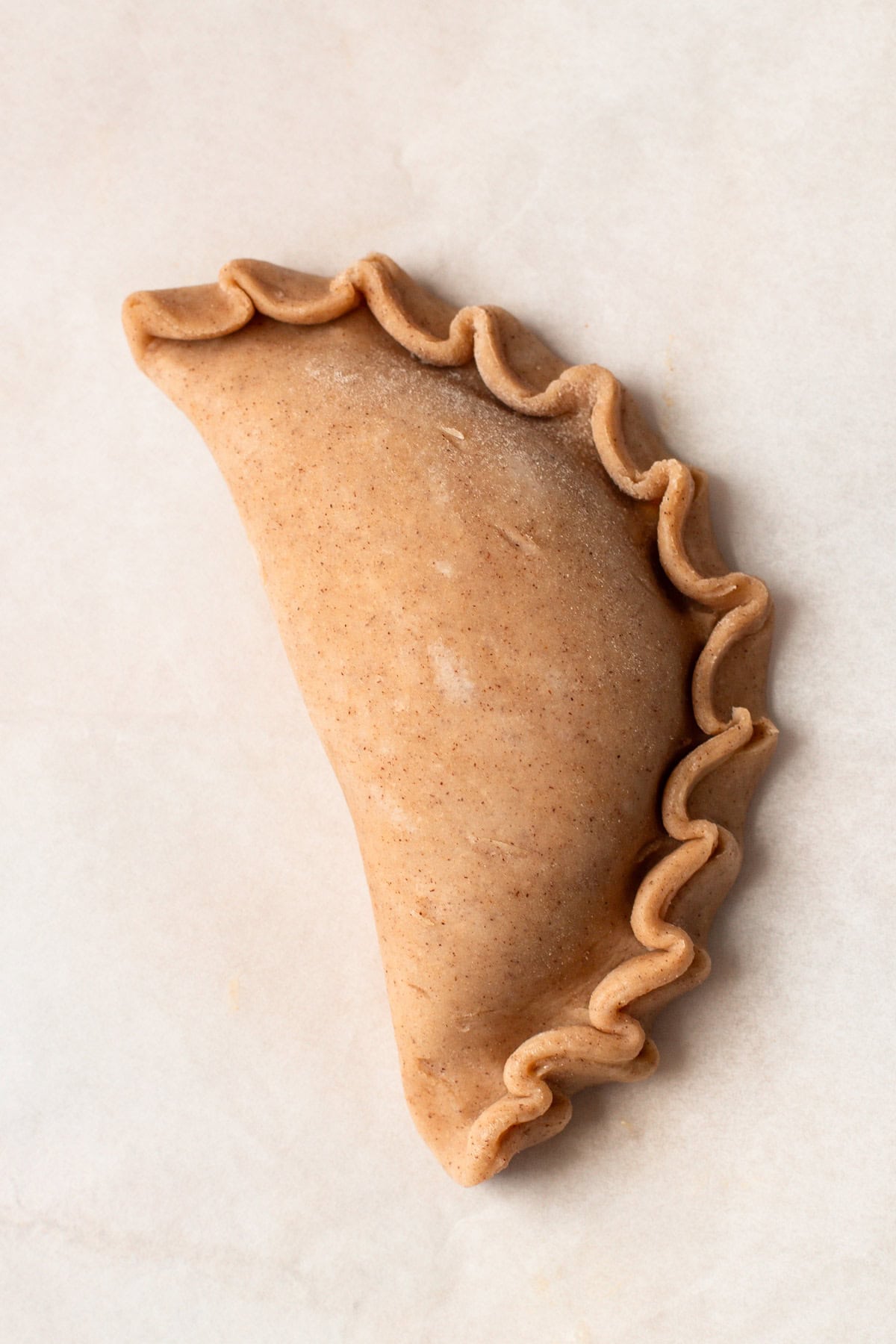 Crimped pumpkin pasty dough, prepped for baking.