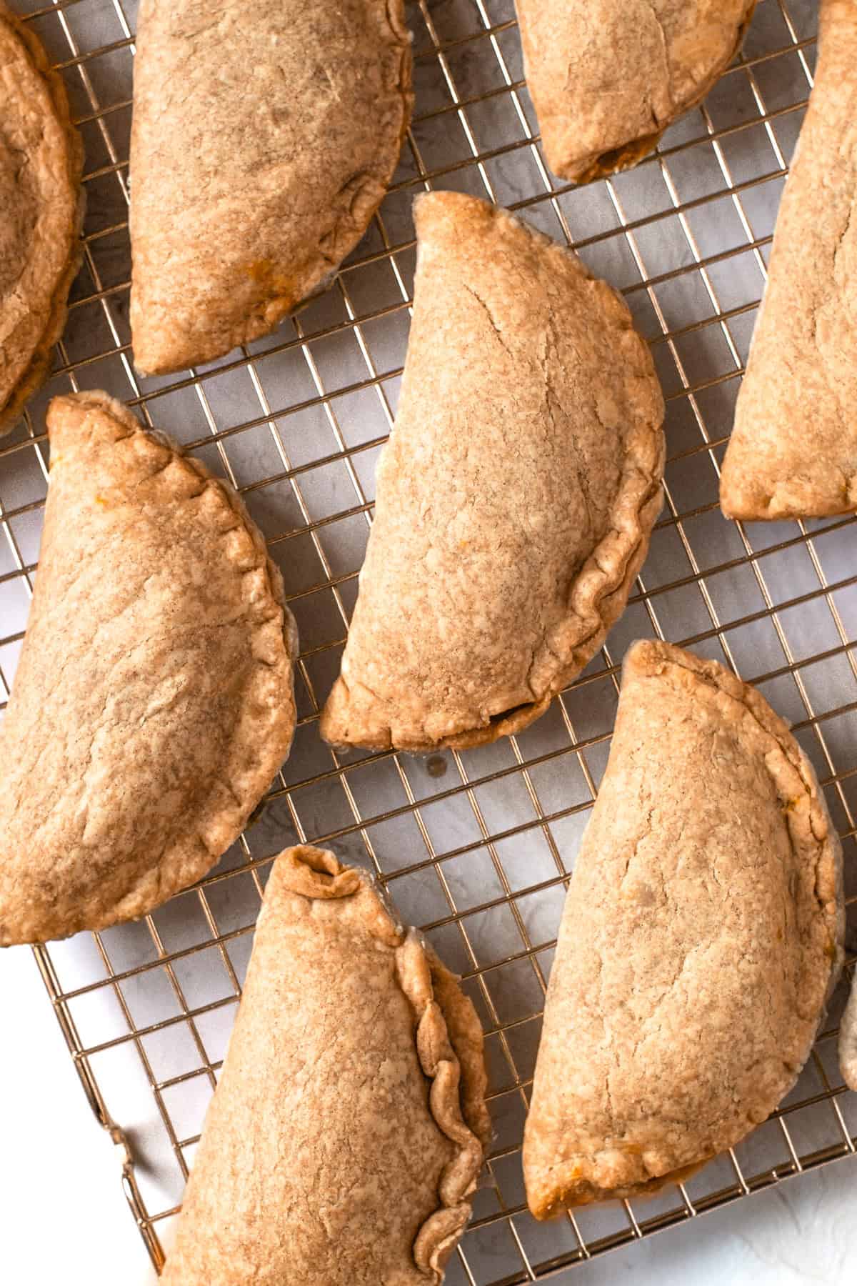 Baked pumpkin pasties on a cooling rack.