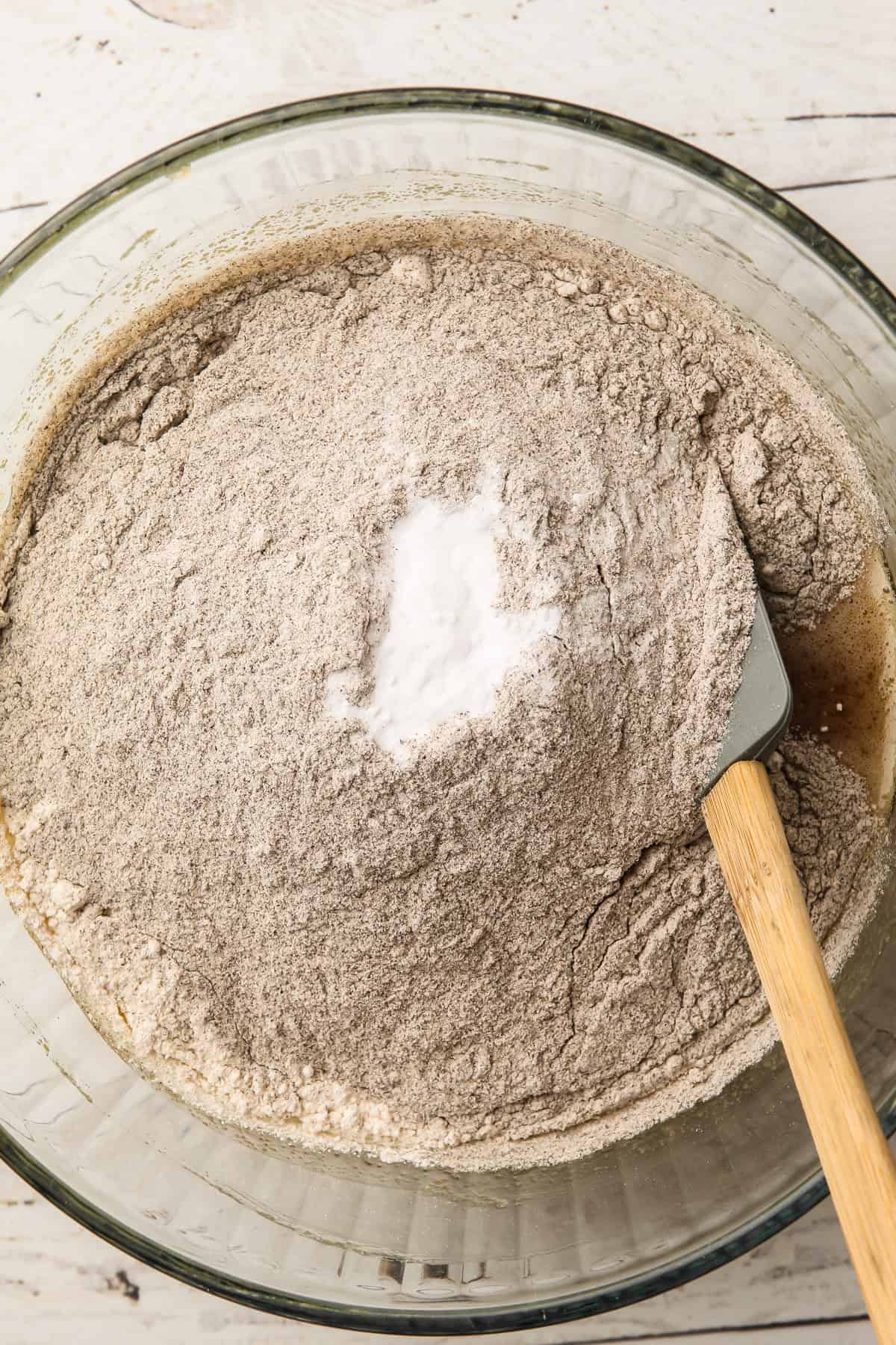 Dry ingredients, including buckwheat flour and oat flour, added to a mixing bowl for cookies.