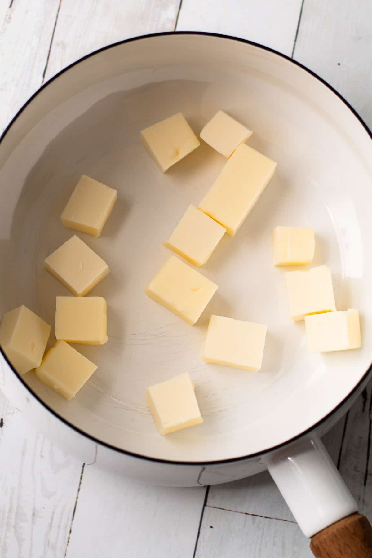 Butter cubes in a white saucepan ready to be browned for oat buckwheat chocolate chip cookies.