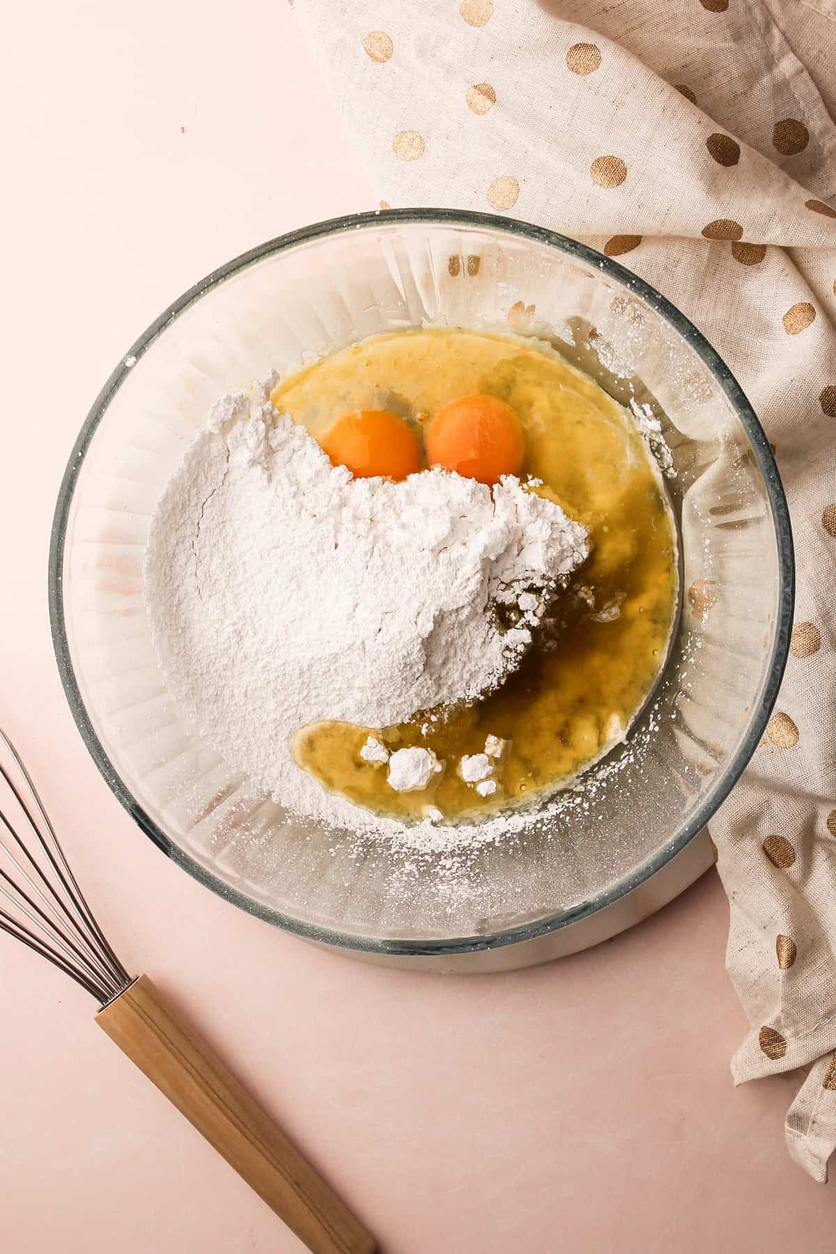 A glass bowl filled with eggs, flour, and other ingredients for a pizzelle recipe.