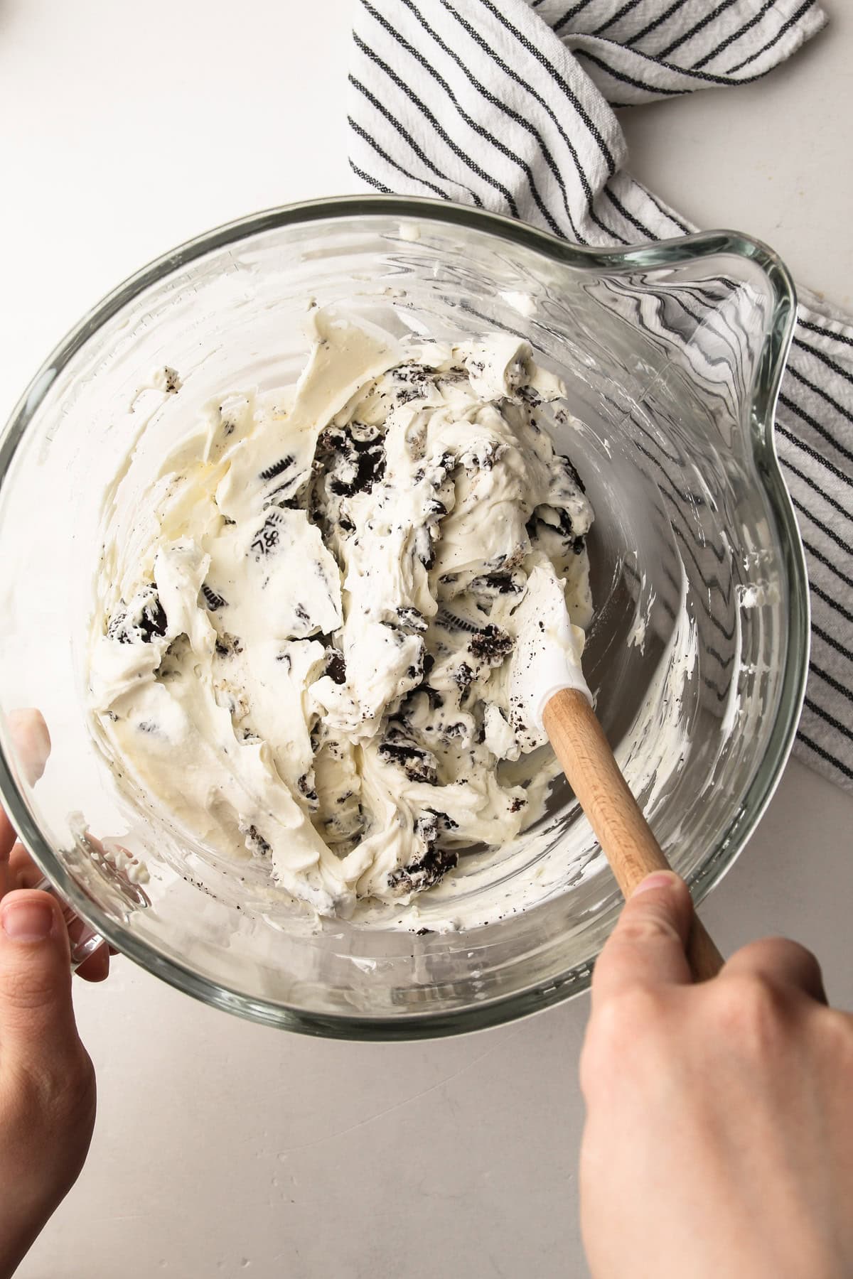 Folding crushed cookies into the filling for an oreo pie.