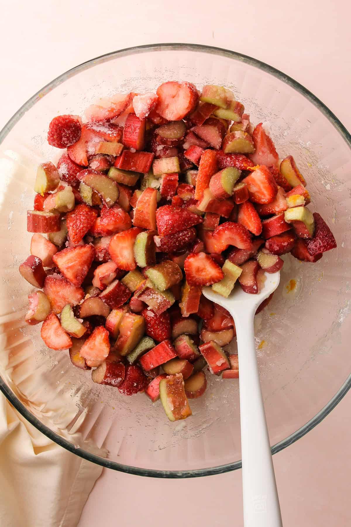 Fruit for a strawberry rhubarb crisp being mixed up in a bowl.
