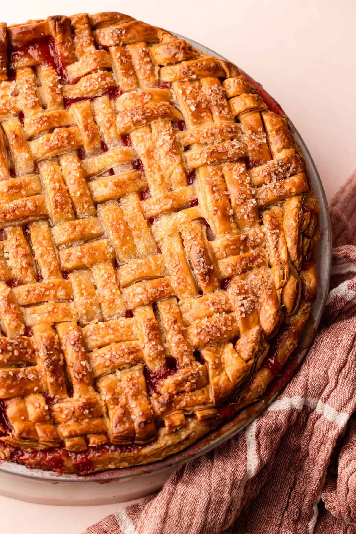 A baked lattice topped strawberry rhubarb pie.