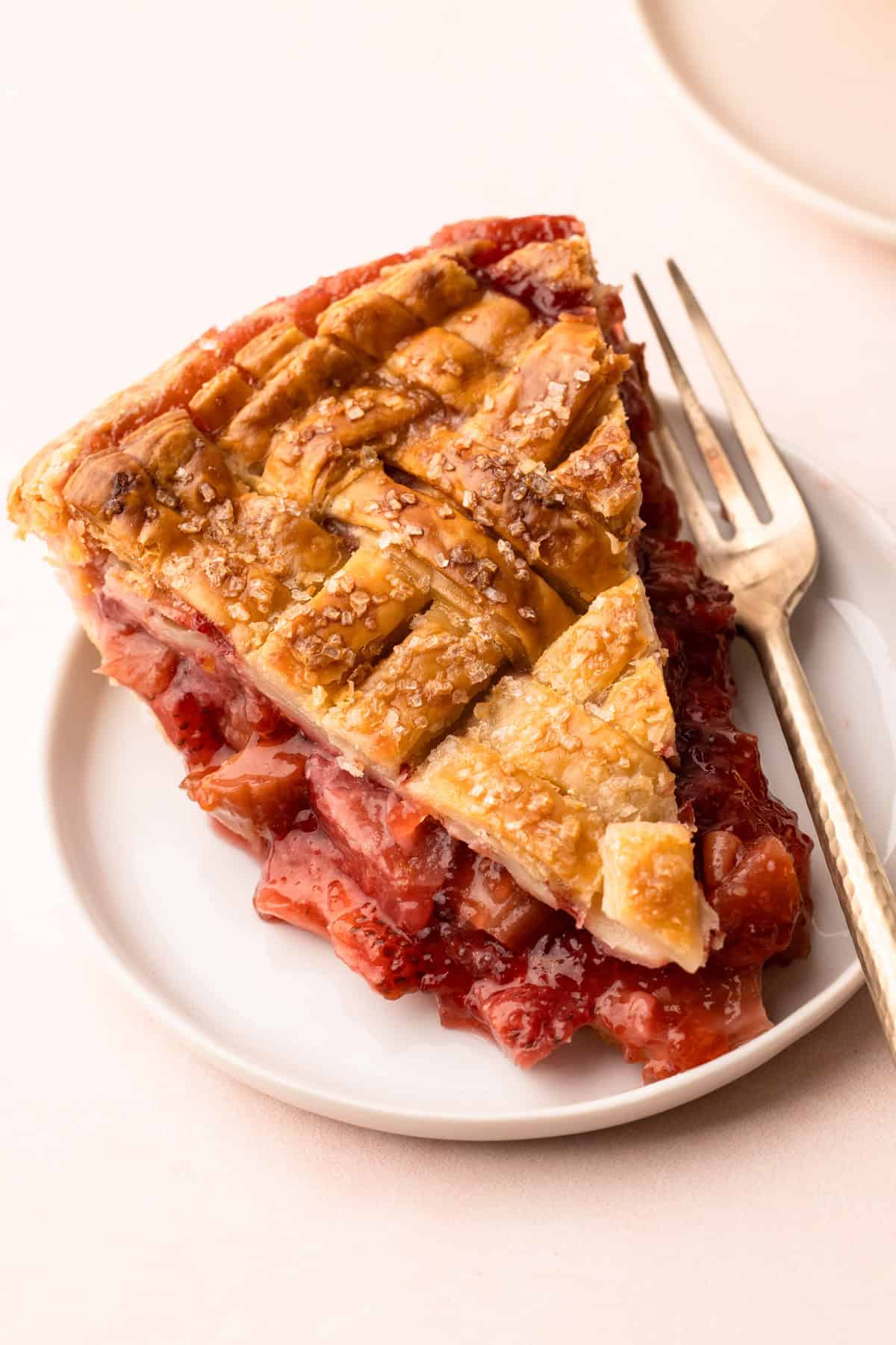 A slice of strawberry rhubarb pie on a plate.