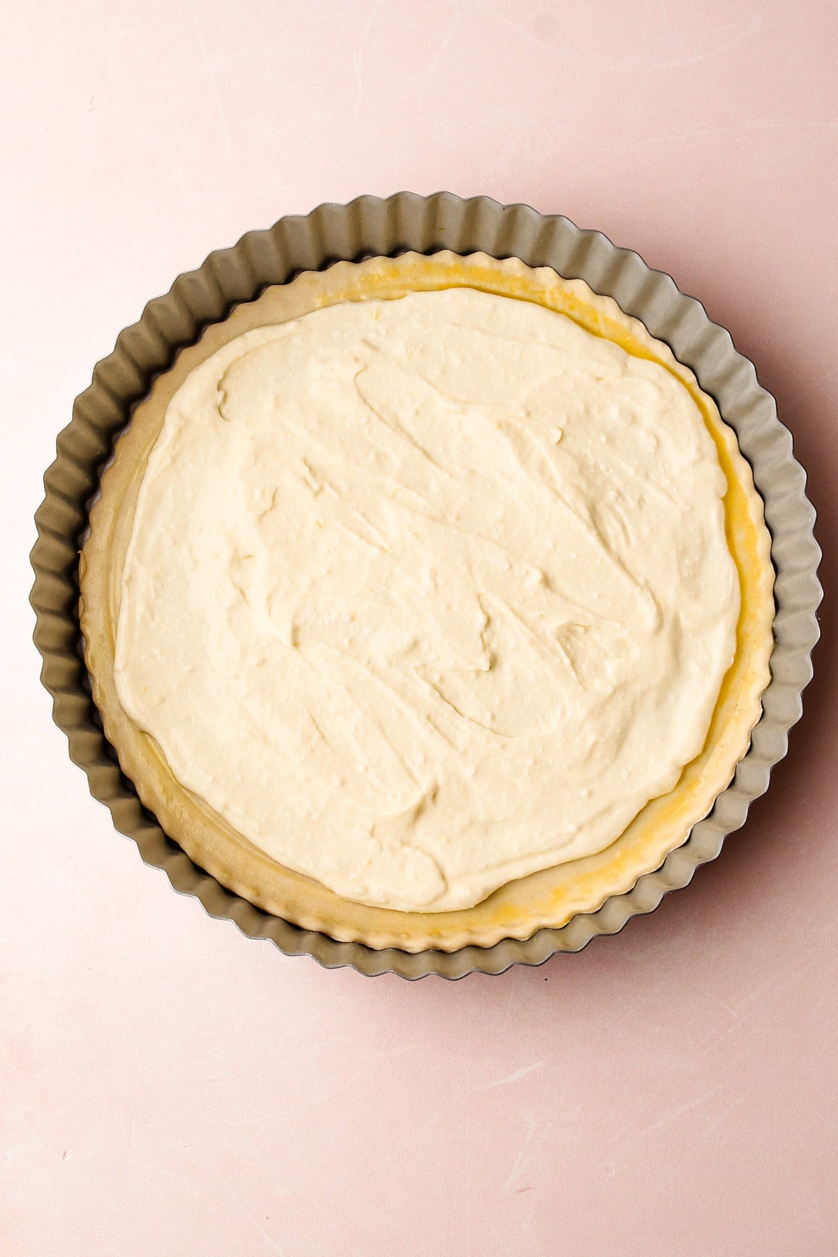 The ricotta filling spread inside a tart shell, ready to assemble a ricotta asparagus tart.