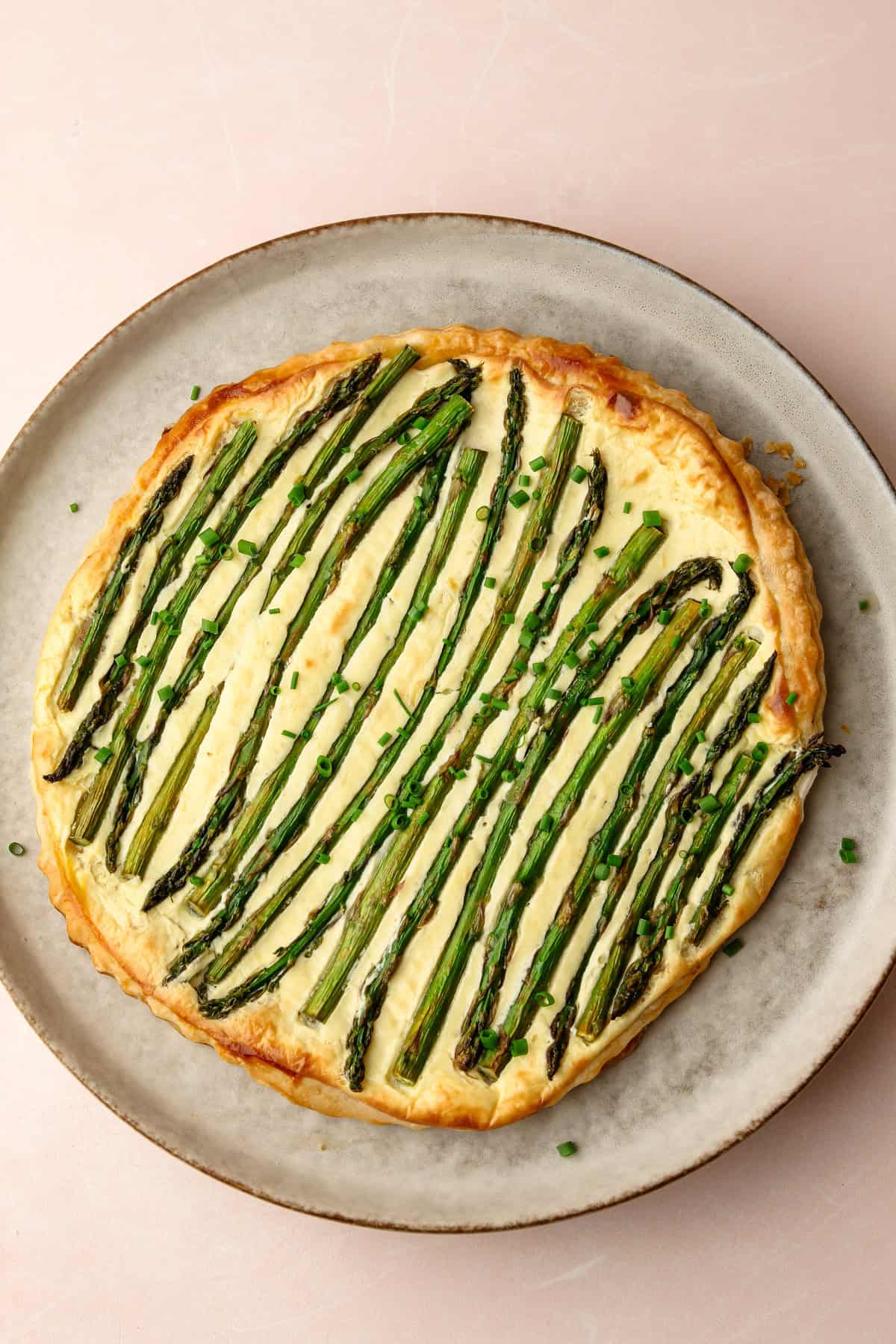A baked lemon ricotta asparagus tart on a plate.