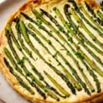 A baked lemon asparagus tart topped with roasted asparagus and chopped chives.