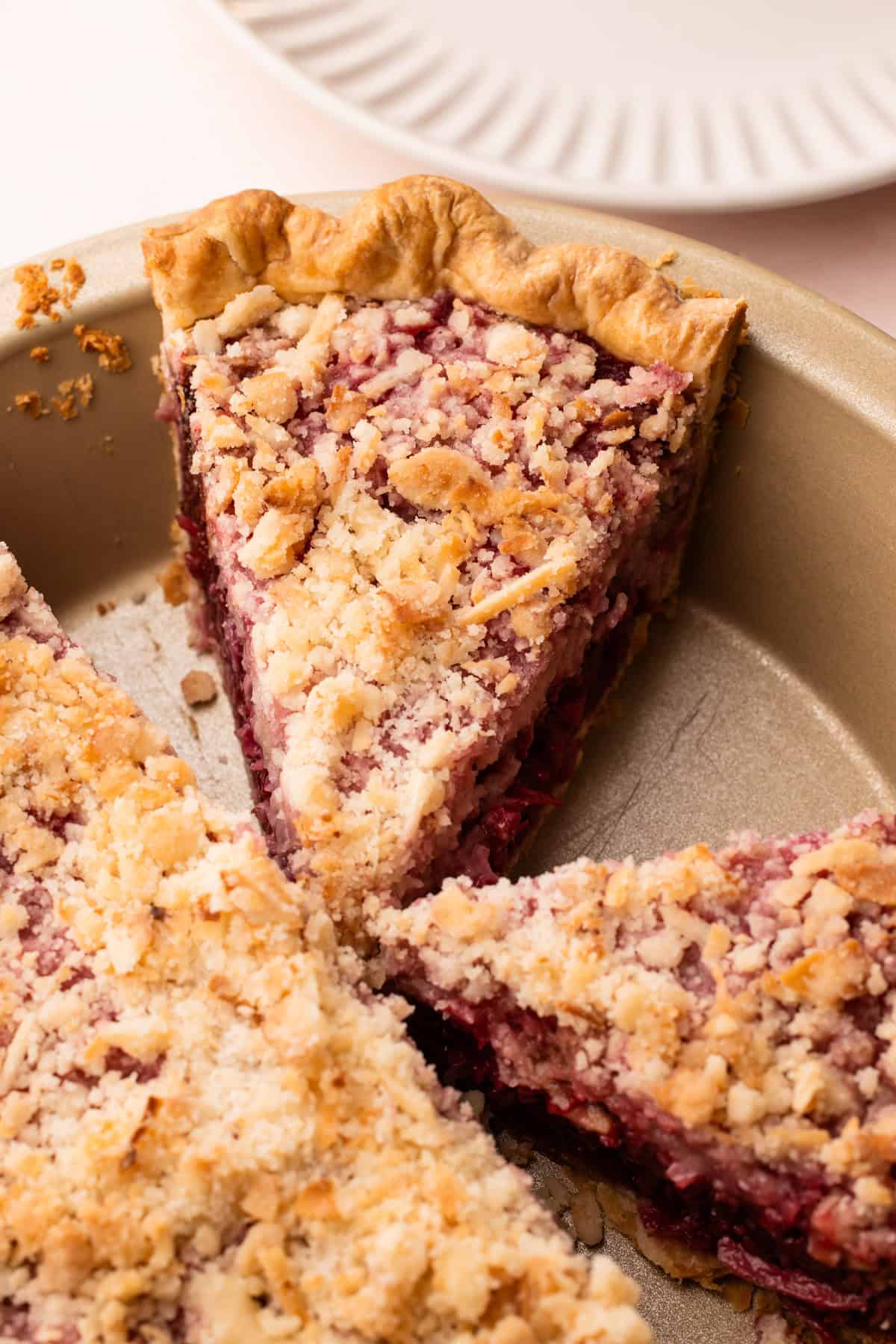 A baked and sliced raspberry coconut macaroon pie.