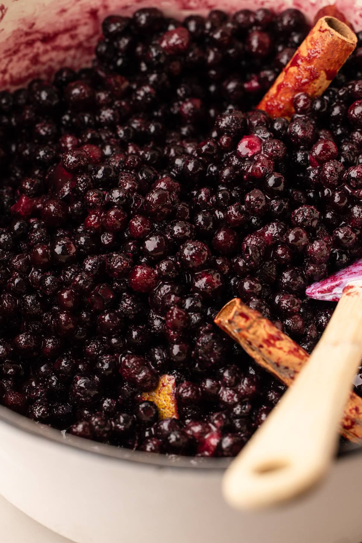Blueberries in a bowl with ingredients to make pie filling.