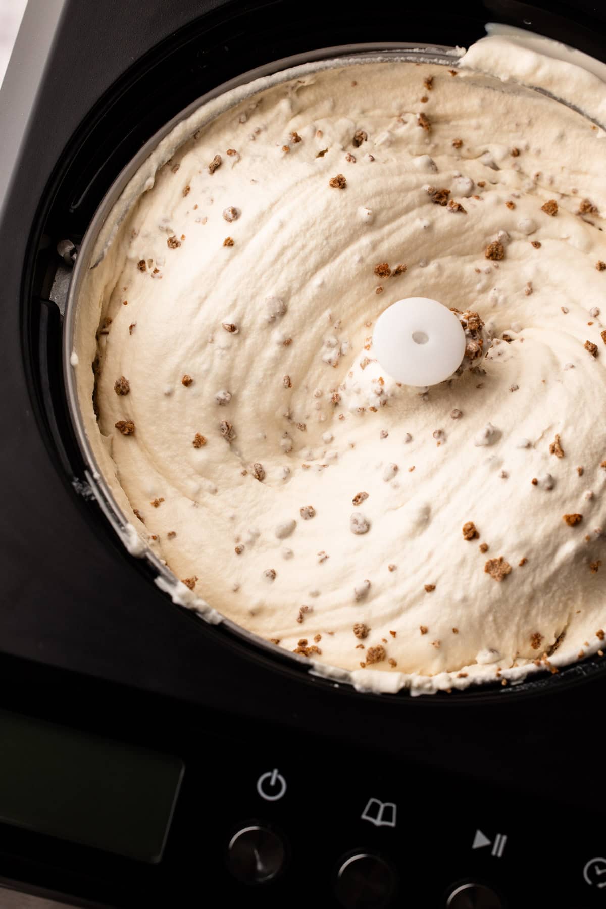 An ice scream machine spinning homemade grapenut custard ice cream, with the grapenuts stirred in.