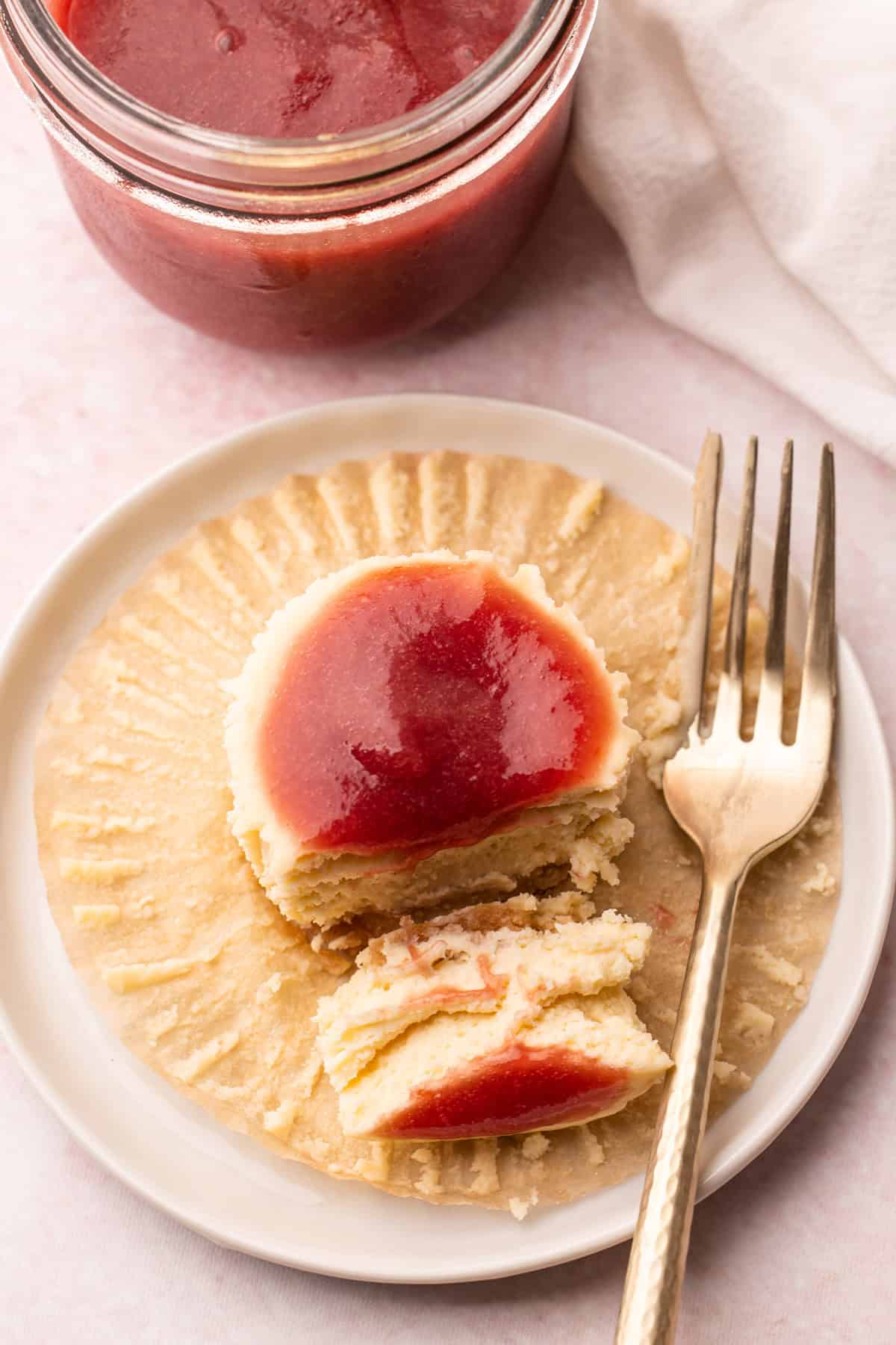 Prepared rhubarb coulis in a jar and on top of a cheesecake.