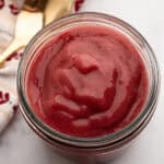 Vibrant red prepared Rhubarb coulis in a jar.