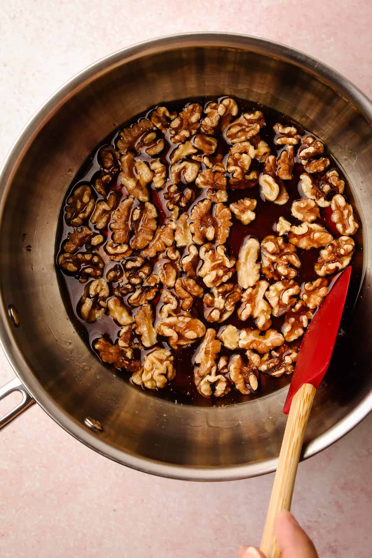 Walnuts sitting in a pot with maple syrup.