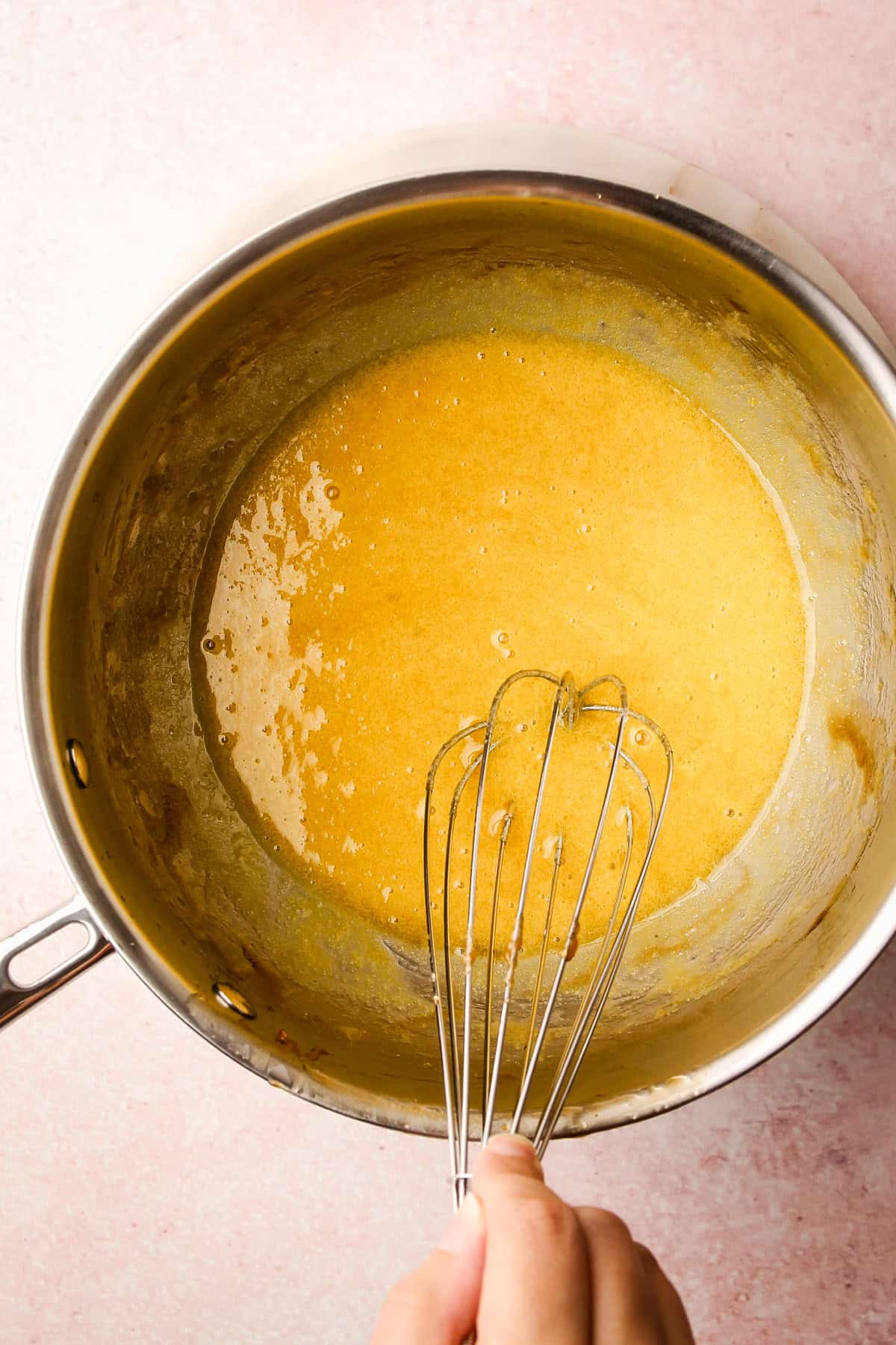 Egg yolks and sugar whisked together in a pot for maple ice cream.