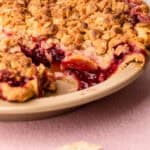 A baked nectarine plum pie with a slice taken out of it.