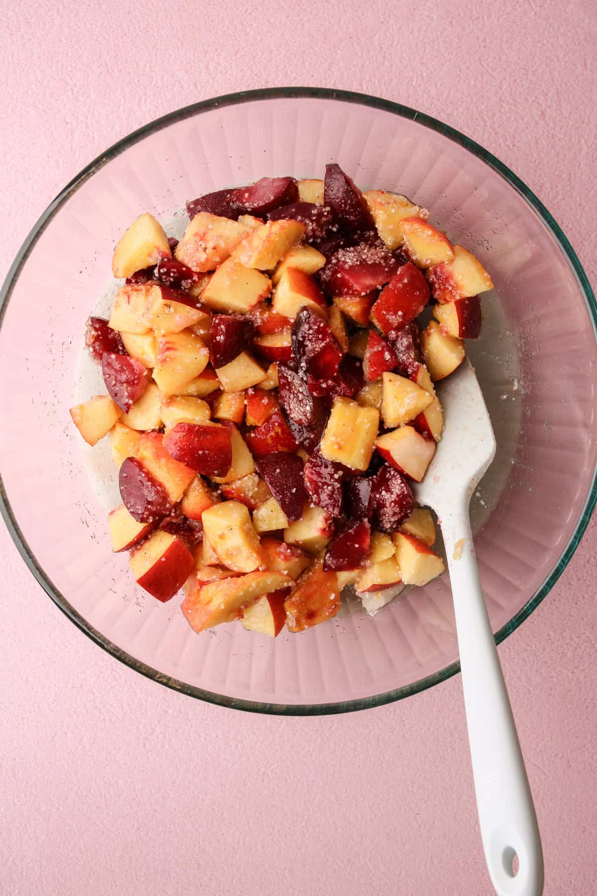 The filling for a nectarine plum pie macerating in a bowl.