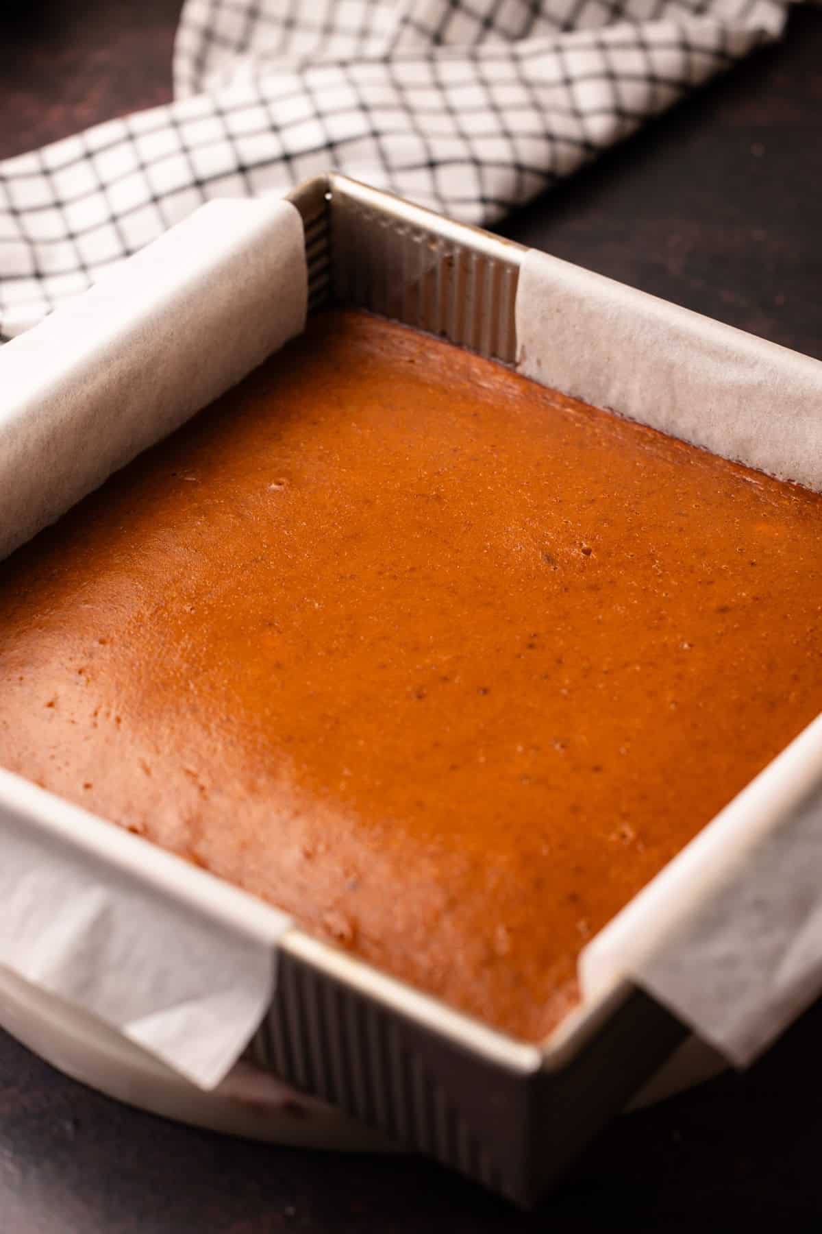 Pumpkin pie bars just pulled from the oven showing a puffed up filling.