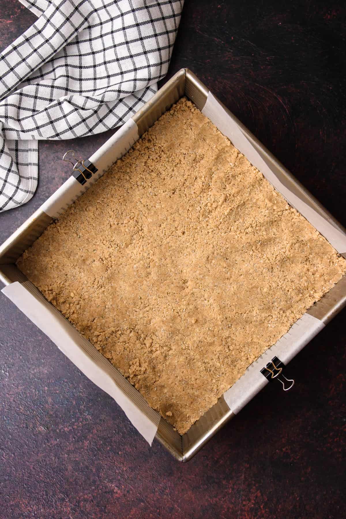 The shortbread crust patted down into an even layer in the prepared baking dish.