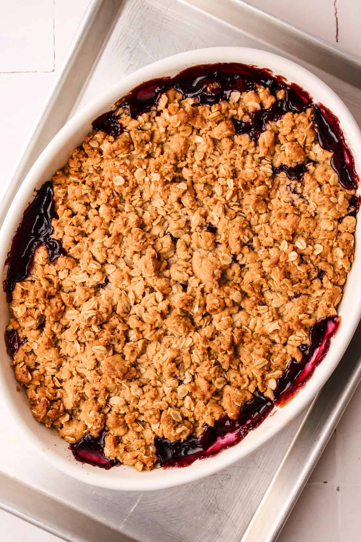 A baked blueberry apple crisp fresh from the oven on a rimmed baking sheet.