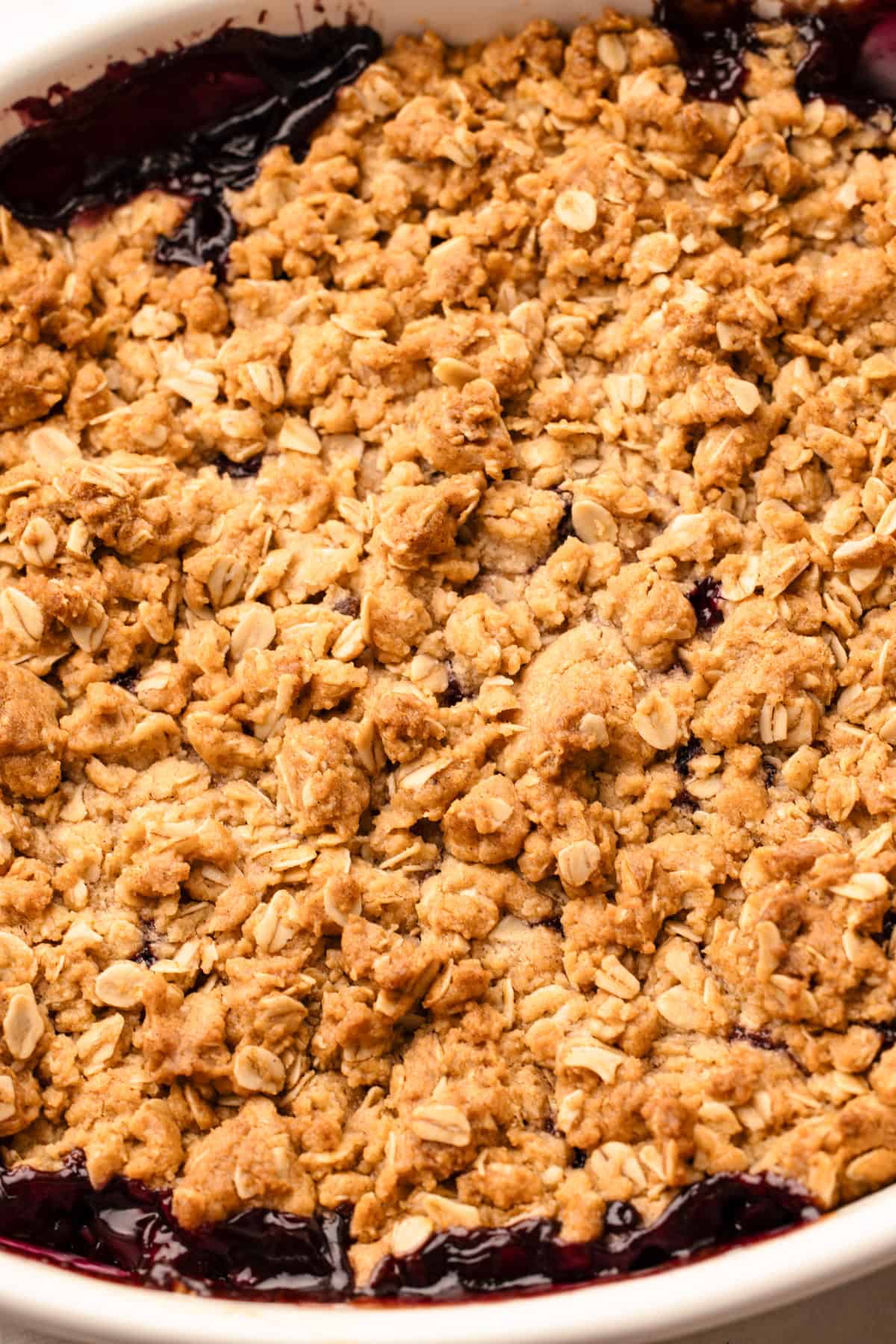 Baked apple blueberry crisp in a white oval dish.