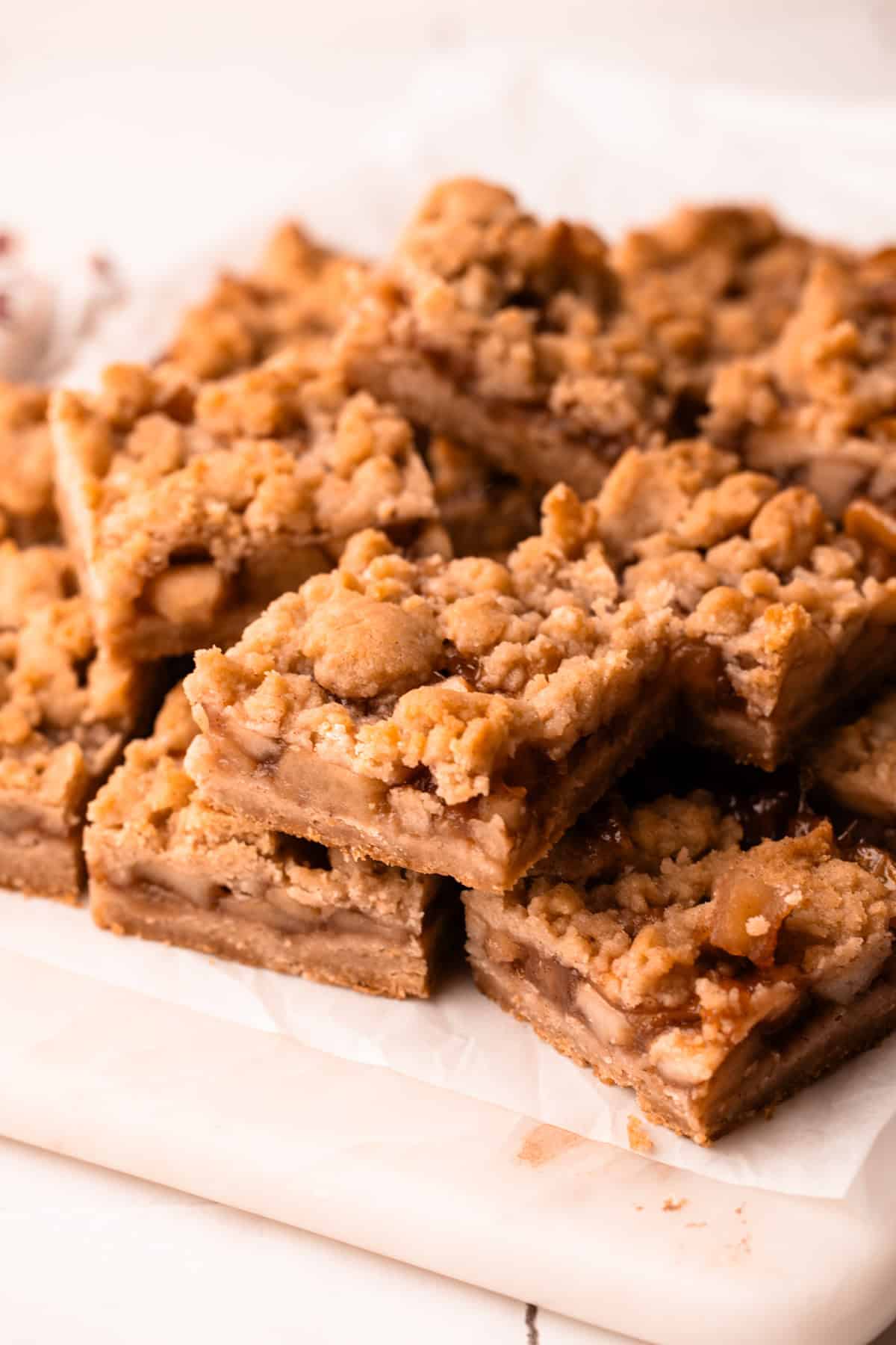 Sliced and served apple pie bars on a marble board.