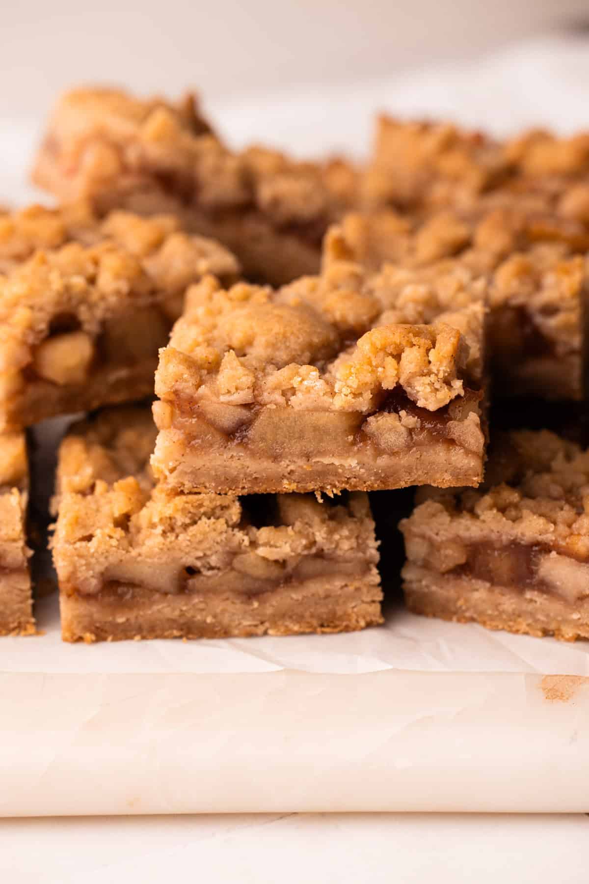 Sliced and served apple pie bars on a marble board.