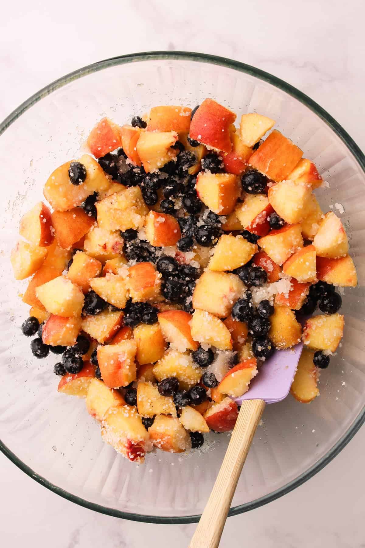 The filling for a peach and blueberry pie in a bowl.