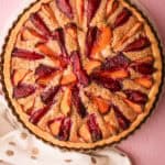A baked plum pie featuring different colored plums.