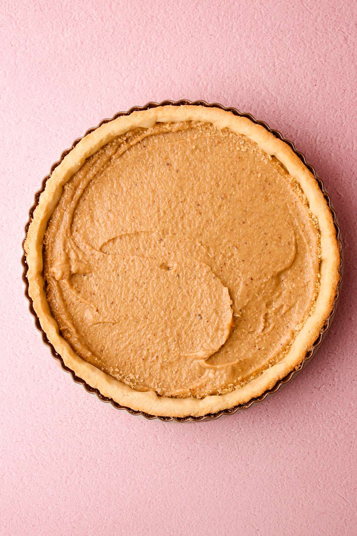 Assembling a tart plum with walnut frangipane.