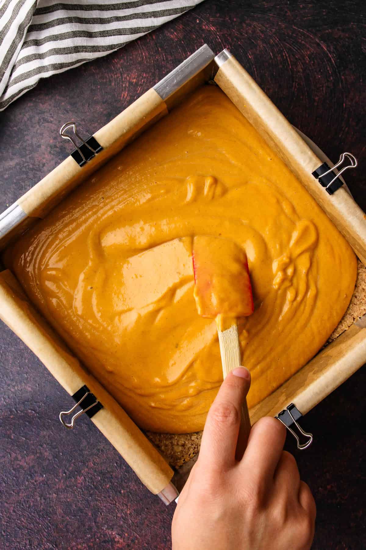 Spreading the sweet potato filling onto the baked crust.