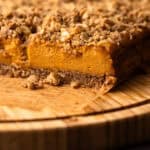 A sliced sweet potato pie bar on a wooden board for serving.