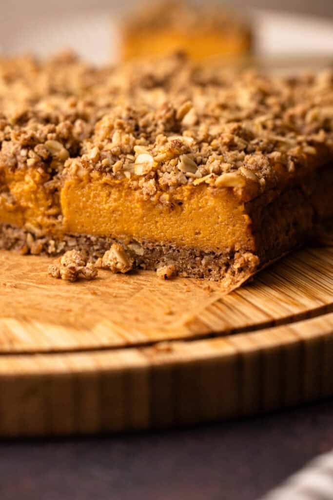 A sliced sweet potato pie bar on a wooden board for serving.