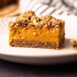 A sweet potato bar with a pecan topping served on a white plate.
