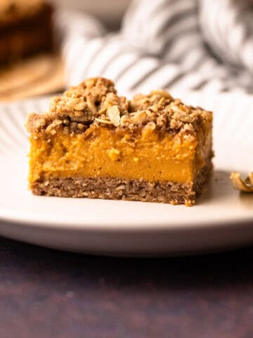 A sweet potato bar with a pecan topping served on a white plate.