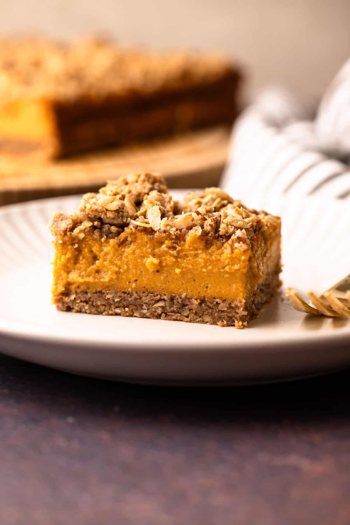 A sweet potato bar with a pecan topping served on a white plate.